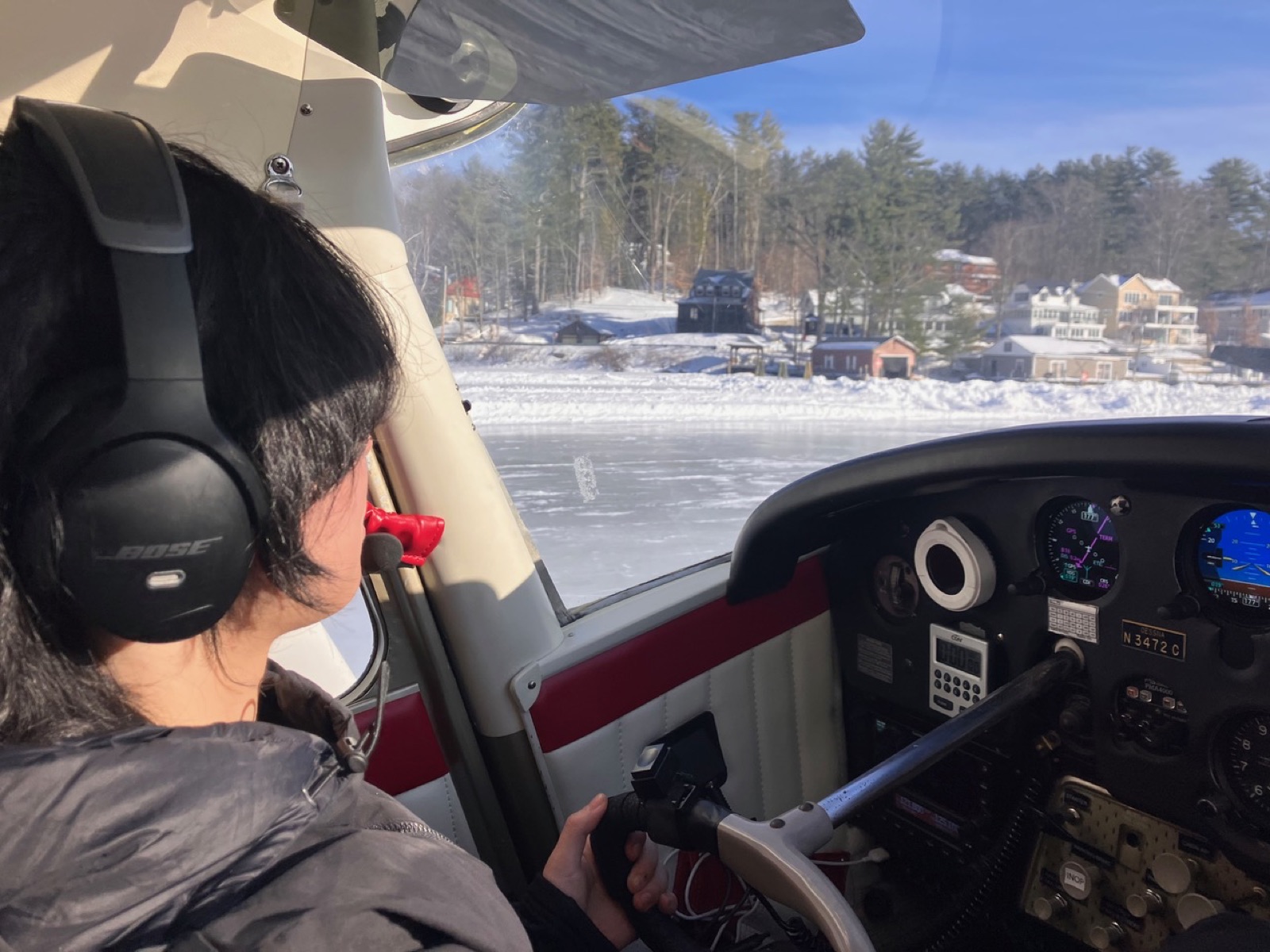 Zoey at the controls of N3472C on the ice at Alton Bay